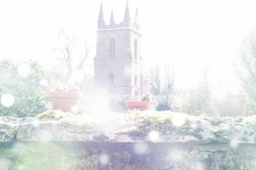 Bright Spring or Christmas background with church, flower pots and white bokeh effect